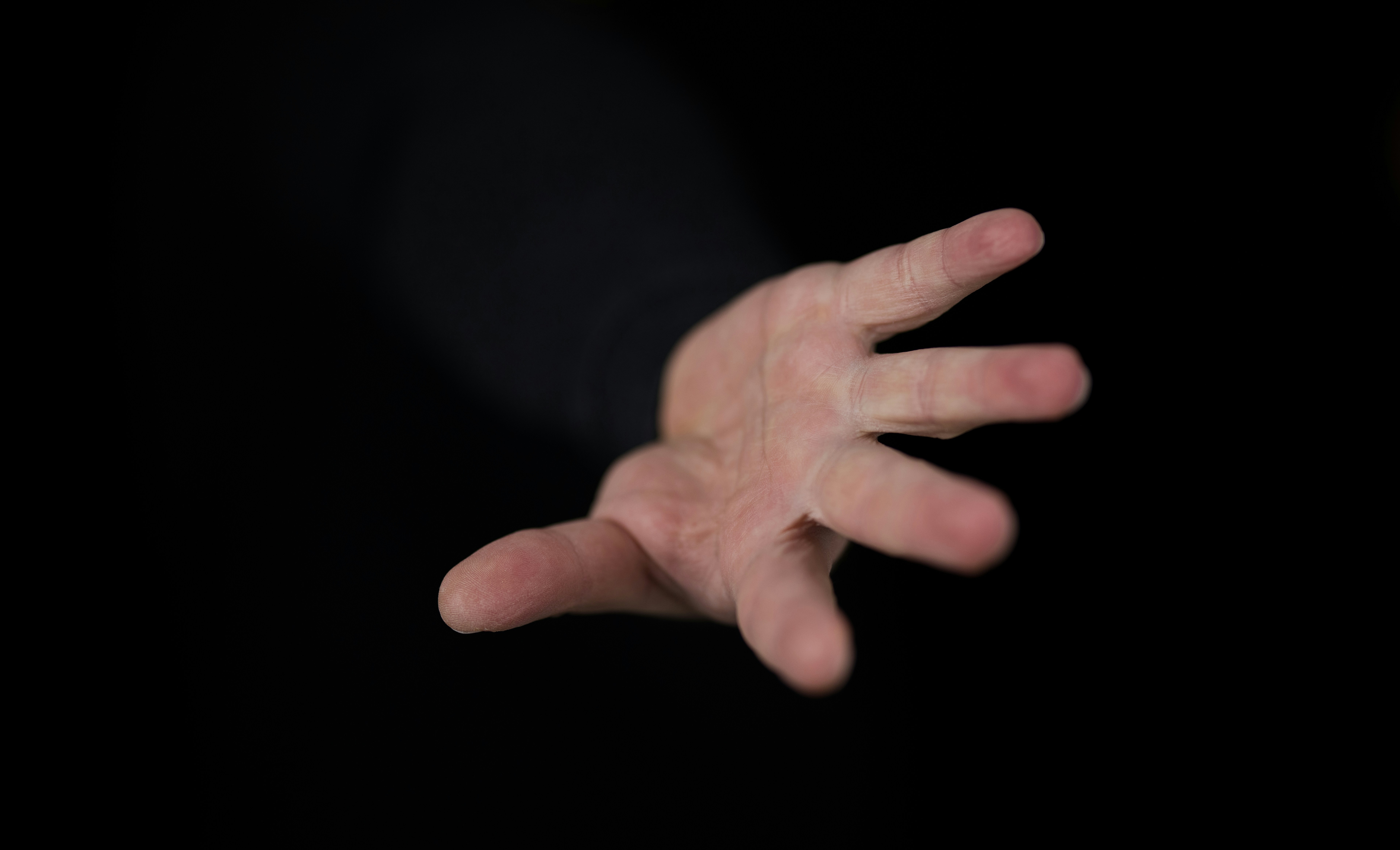 A hand reaching up from the depths of darkness
